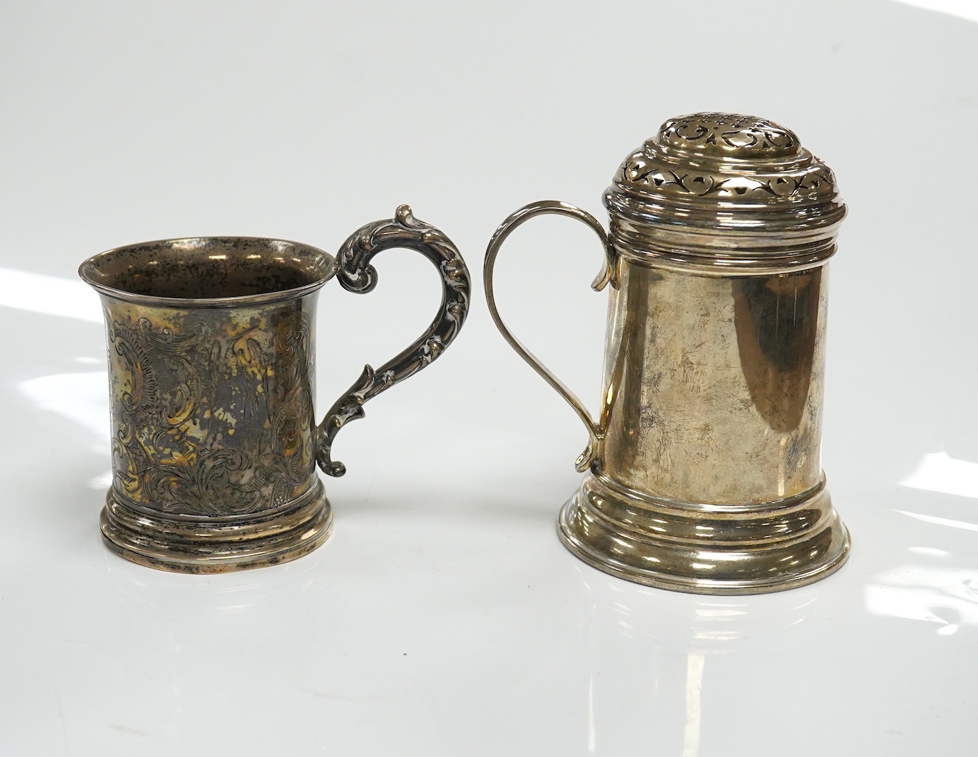 A George V Brittania standard silver kitchen pepper, by John Charles Lowe, London, 1935, 11.5cm and a Victorian silver christening mug, 10.4oz. Condition - poor to fair